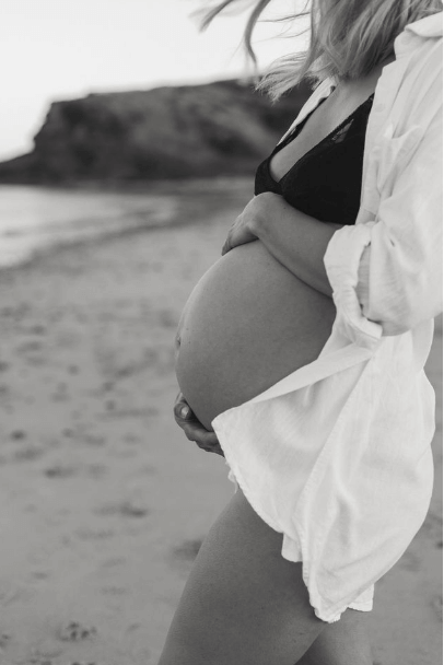 third trimester pregnant woman on beach